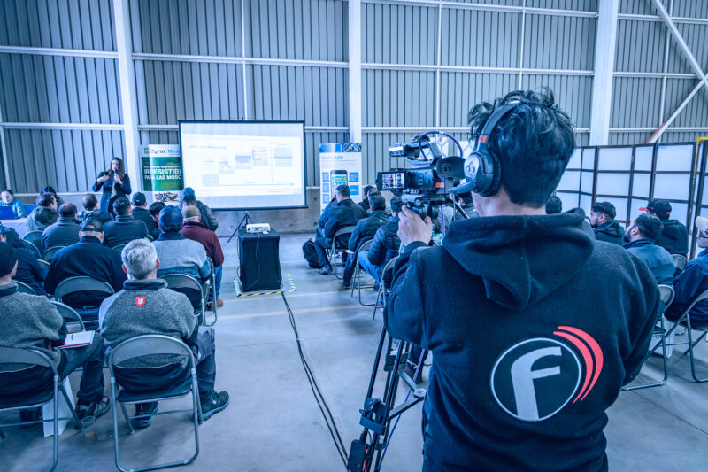 Transmisión en vivo de la charla de Copargo Control en su centro logístico en Renca, Santiago de Chile. Asistentes atentos a la presentación sobre innovaciones en control de plagas por Syngenta.